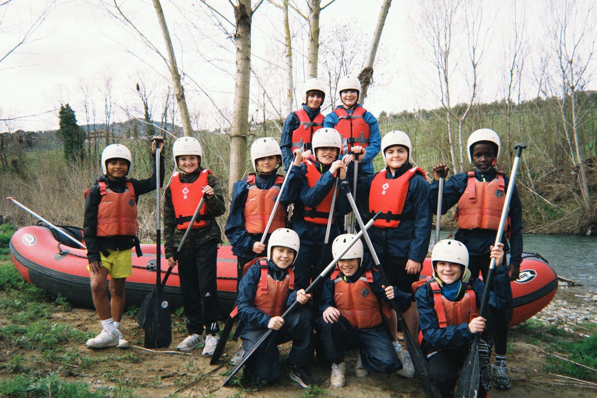 Classe con caschi e pagaie prima del rafting in Toscana