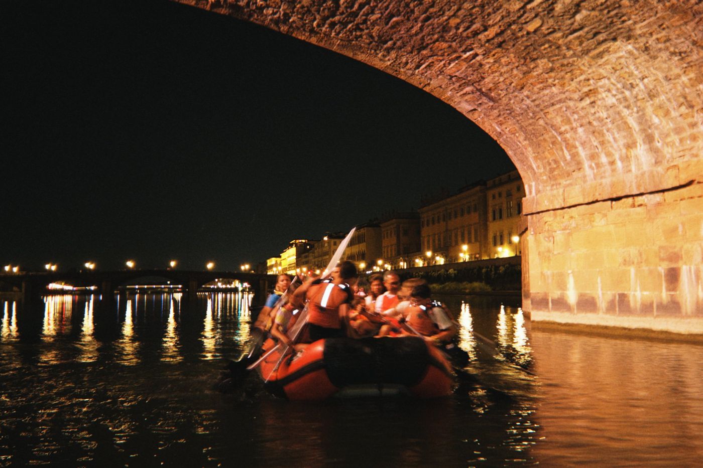 Rafting di sera sotto un ponte sull'Arno a Firenze