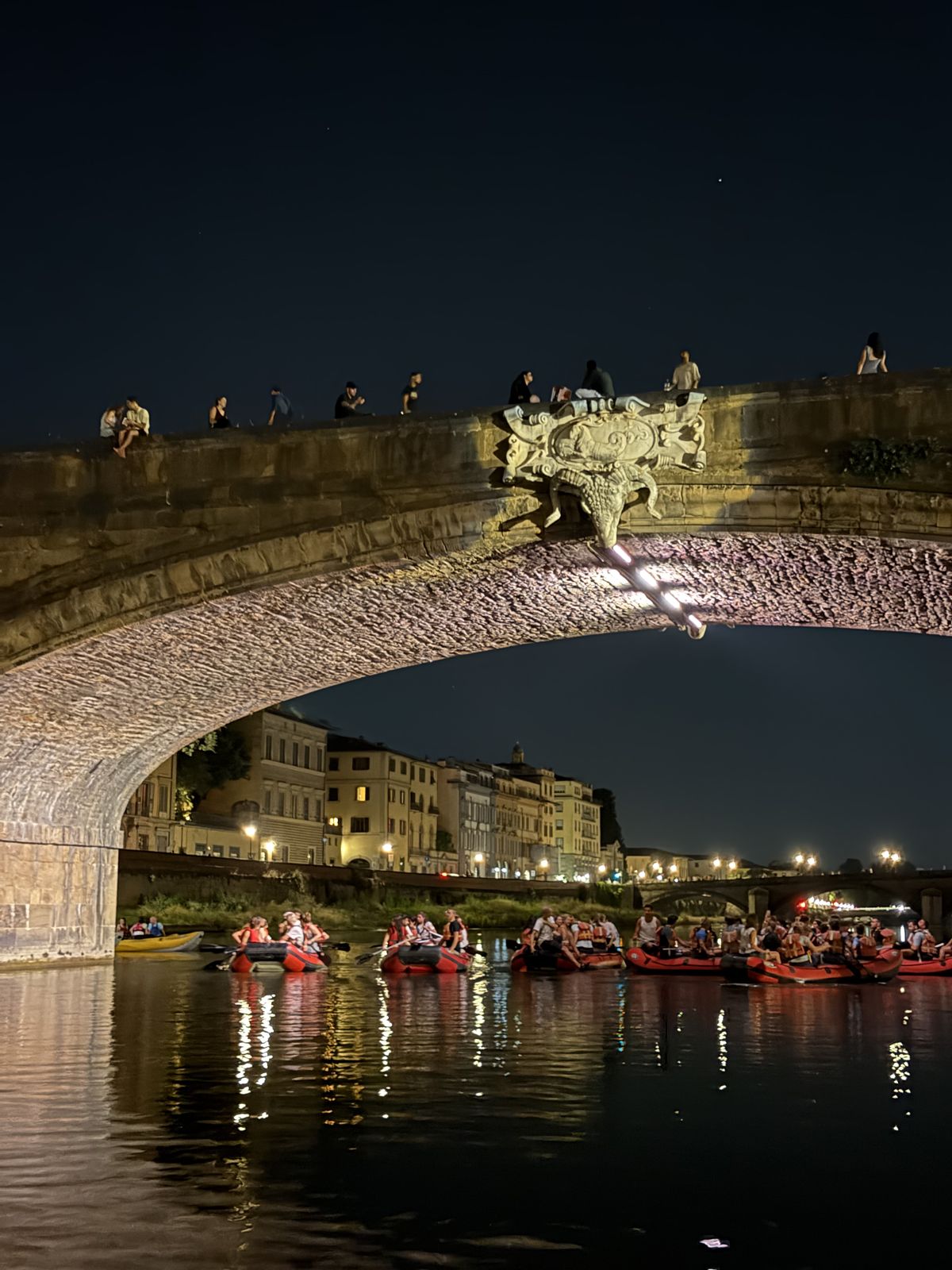 Gommoni sull'Arno sotto un ponte di Firenze la sera del 24 giugno