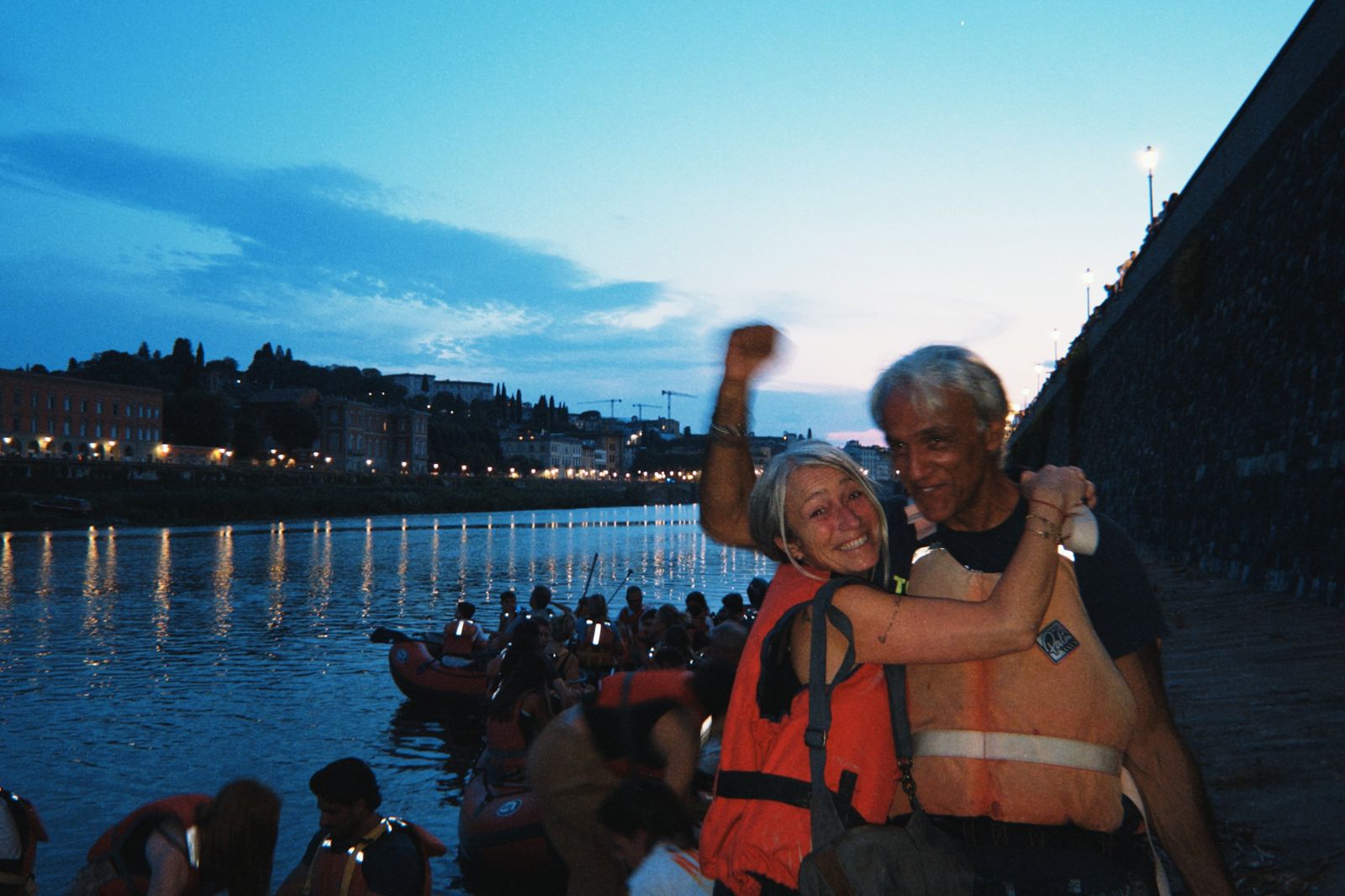 Partecipanti felici sulla riva dell'Arno al tramonto prima dei fuochi di San Giovanni