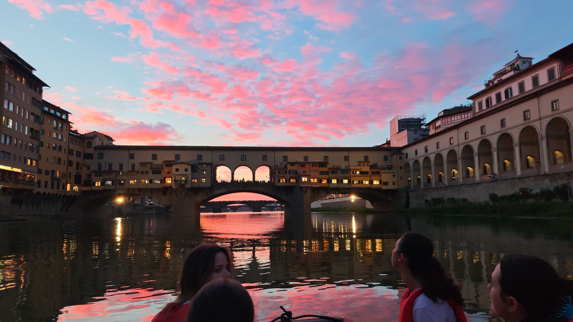 In gommone sull'Arno sotto Ponte Vecchio al tramonto